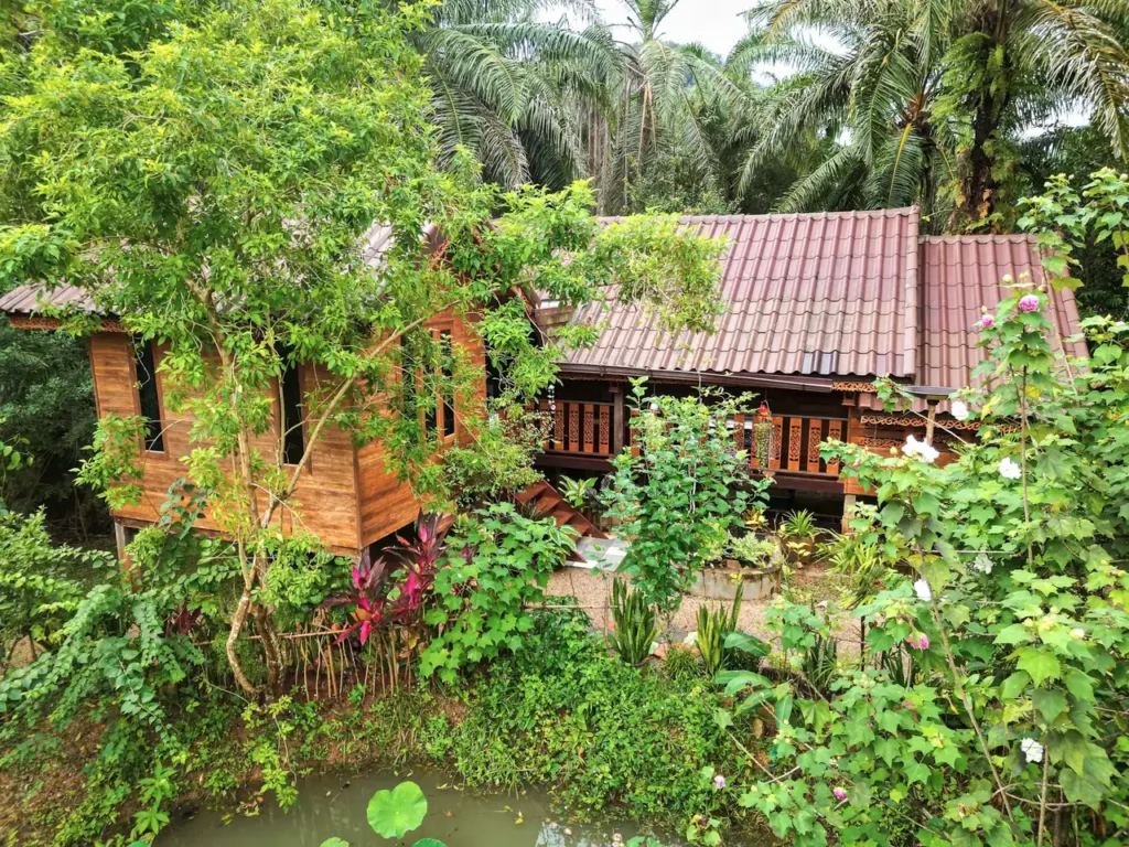 Teak Thai stilt house surrounded by tropical garden in Krabi