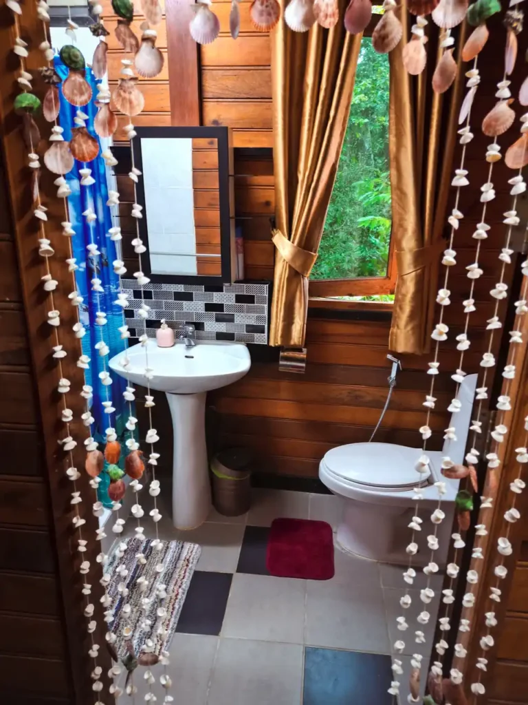 Cozy Krabi rental bathroom with wooden walls and tropical garden view
