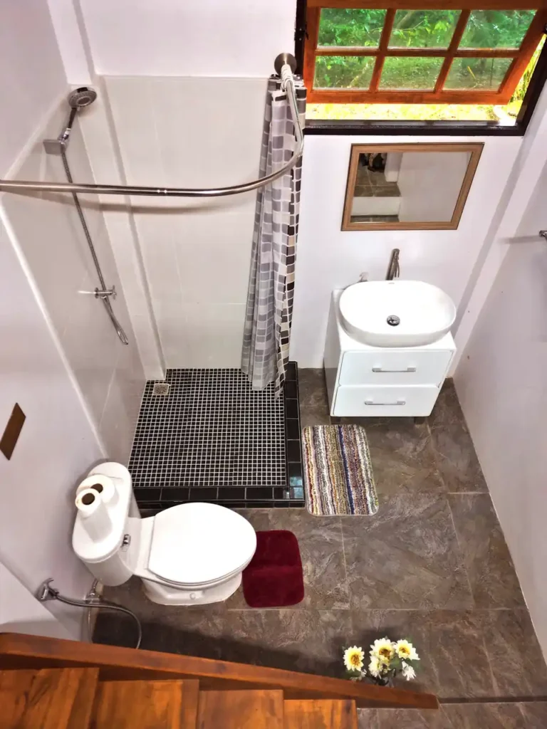 Compact Krabi teak house bathroom with shower and garden window