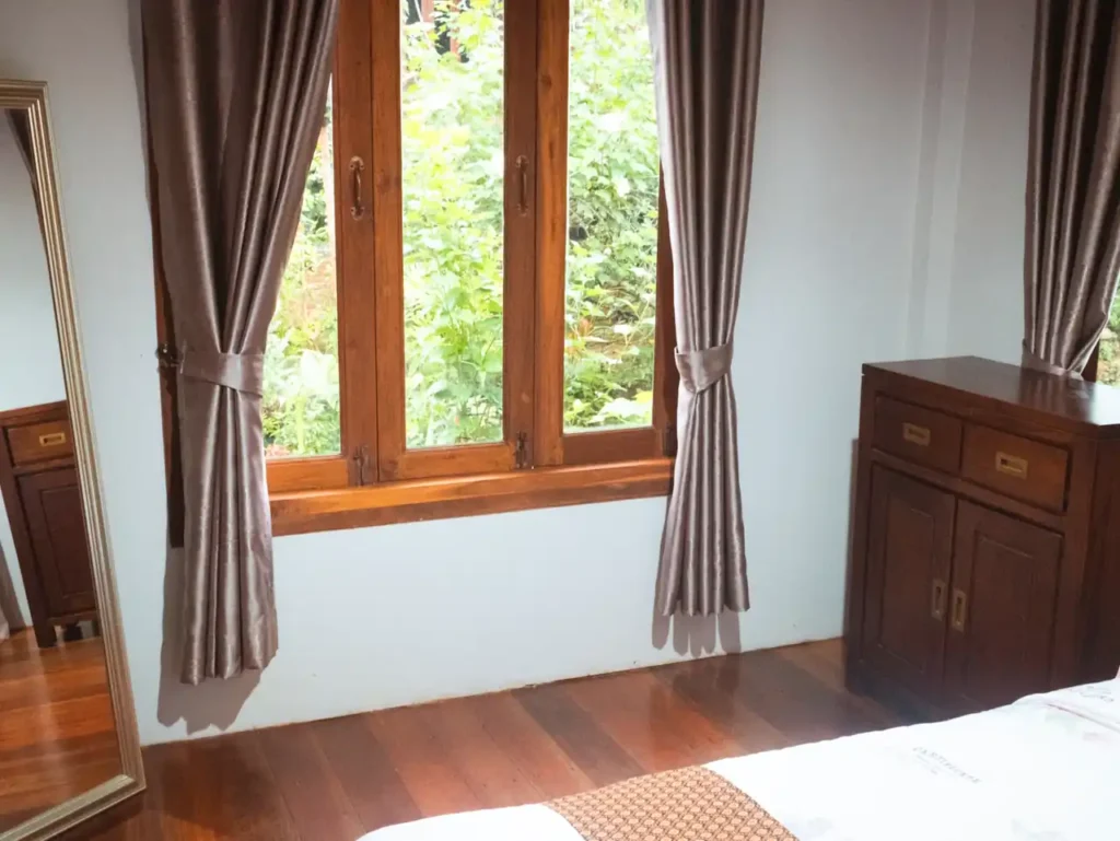 Serene Krabi rental bedroom with wooden decor and garden view window