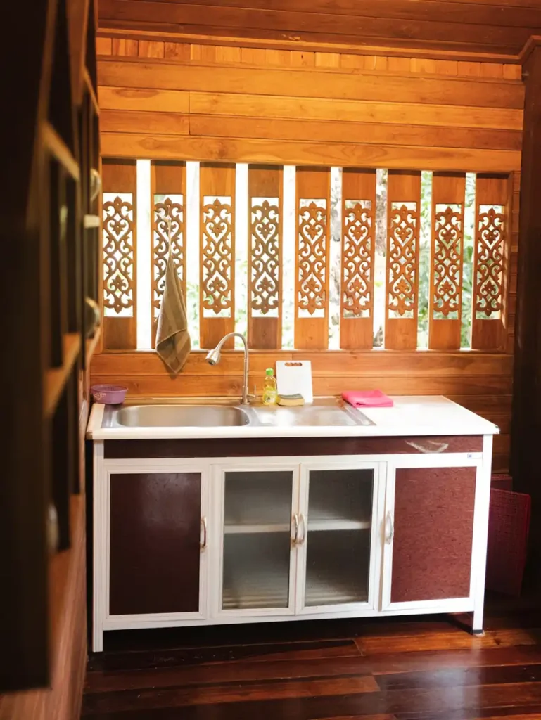 Rustic Krabi teak house kitchen with carved wooden panels and sink